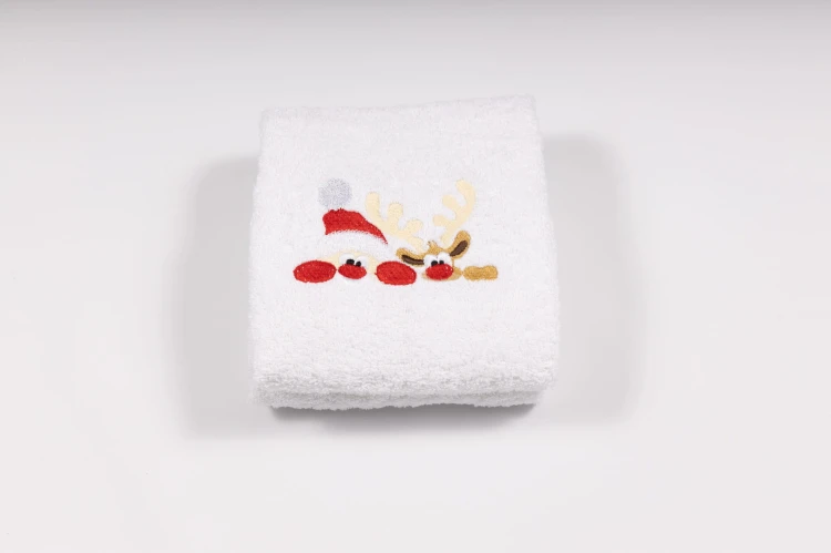 Elegancki świąteczny ręcznik frotte 500g z precyzyjnym haftem przedstawiającym wystającego Mikołaja i wesołego reniferka, idealny na prezent.