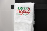 Miękki bawełniany ręcznik świąteczny 500 gsm z napisem Merry Christmas zawieszony na wieszaku w łazience