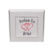 Personalizowany ręcznik z wyhaftowanym napisem Kocham Cię i sercami, zapakowany na prezent w eleganckie białe pudełko z okienkiem.