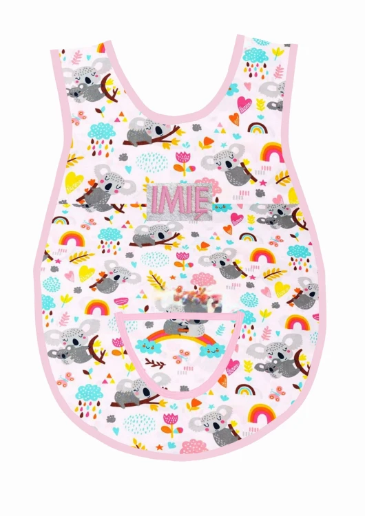 Bawełniany fartuszek do przedszkola z wzorem w misie koala i z dużym personalizowanym haftem imienia oraz nazwiska dziecka, różowa lamówka