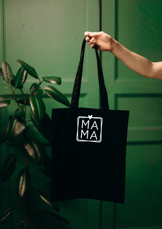 Kobieta niosąca torbę bawełnianą z personalizowanym haftem – praktyczny prezent na Dzień Mamy w użyciu.