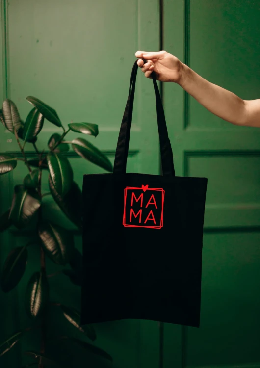 Kobieta niosąca torbę bawełnianą z personalizowanym haftem – praktyczny prezent na Dzień Mamy w użyciu.