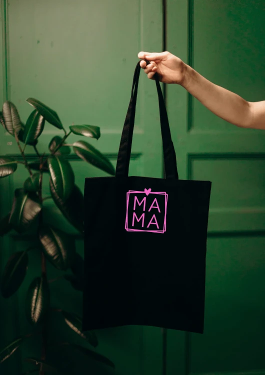 Kobieta niosąca torbę bawełnianą z personalizowanym haftem – praktyczny prezent na Dzień Mamy w użyciu.