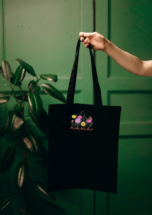 Kobieta niosąca torbę bawełnianą z personalizowanym haftem – praktyczny prezent na Dzień Mamy w użyciu.