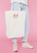 Kobieta niosąca torbę bawełnianą z personalizowanym haftem – praktyczny prezent na Dzień Mamy w użyciu.
