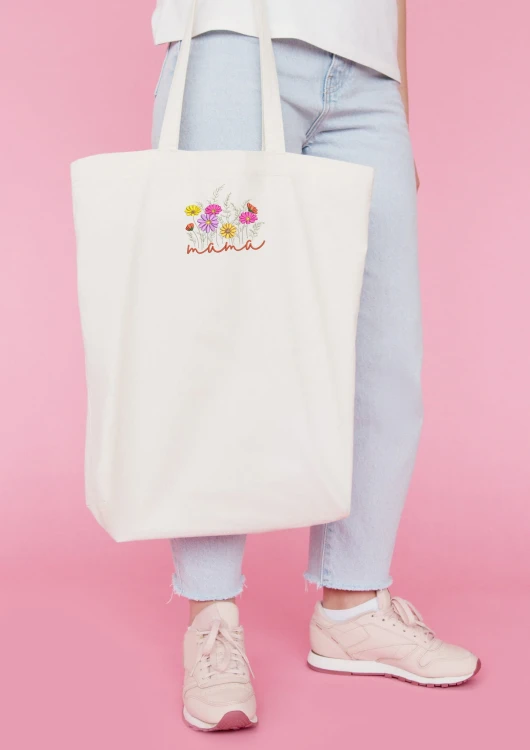 Kobieta niosąca torbę bawełnianą z personalizowanym haftem – praktyczny prezent na Dzień Mamy w użyciu.