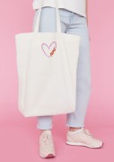Kobieta niosąca torbę bawełnianą z personalizowanym haftem – praktyczny prezent na Dzień Mamy w użyciu.