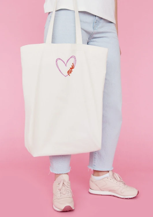 Kobieta niosąca torbę bawełnianą z personalizowanym haftem – praktyczny prezent na Dzień Mamy w użyciu.
