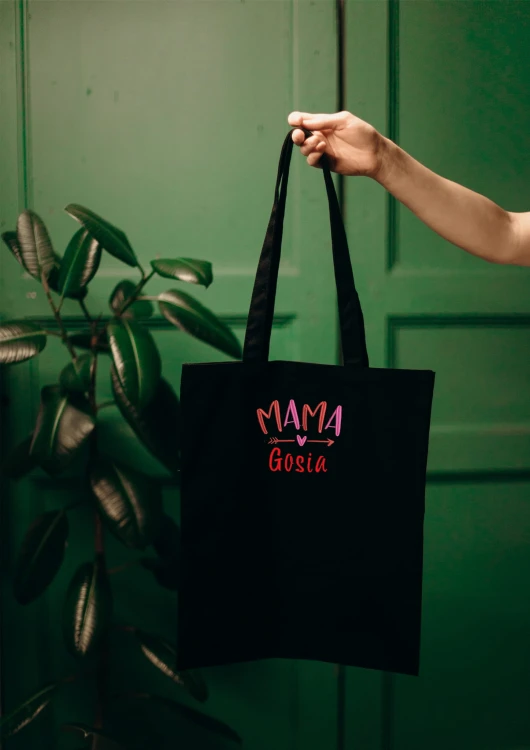 Kobieta niosąca torbę bawełnianą z personalizowanym haftem – praktyczny prezent na Dzień Mamy w użyciu.