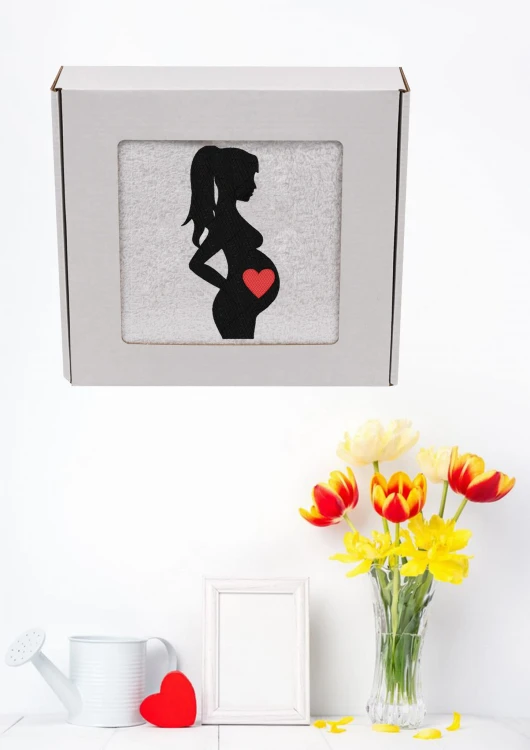 Biały, puszysty personalizowany ręcznik z haftem sylwetki kobiety w ciąży, zapakowany w eleganckie pudełko z okienkiem. Idealny, gotowy prezent na Baby Shower lub Bociankowe. Wykonany ze 100% bawełny frotte o wysokiej gramaturze 500g.