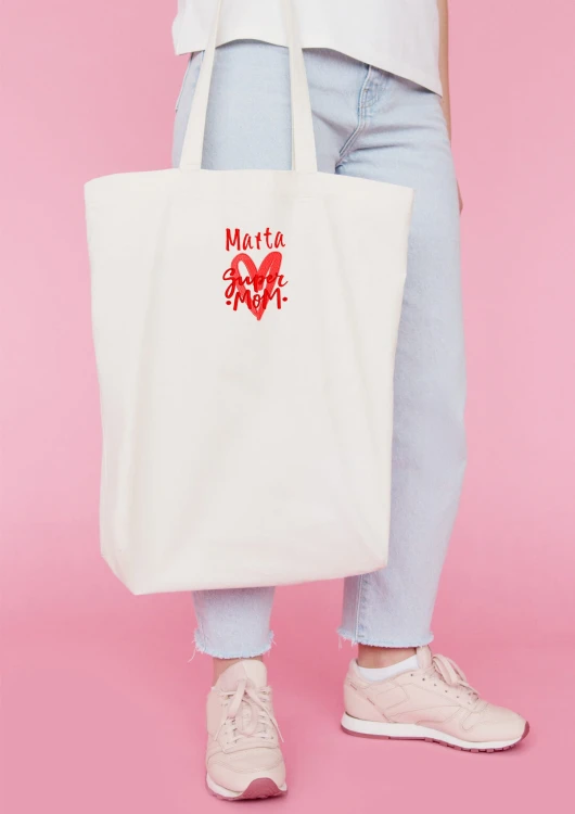 Kobieta niosąca torbę bawełnianą z personalizowanym haftem – praktyczny prezent na Dzień Mamy w użyciu.