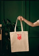 Kobieta niosąca torbę bawełnianą z personalizowanym haftem – praktyczny prezent na Dzień Mamy w użyciu.