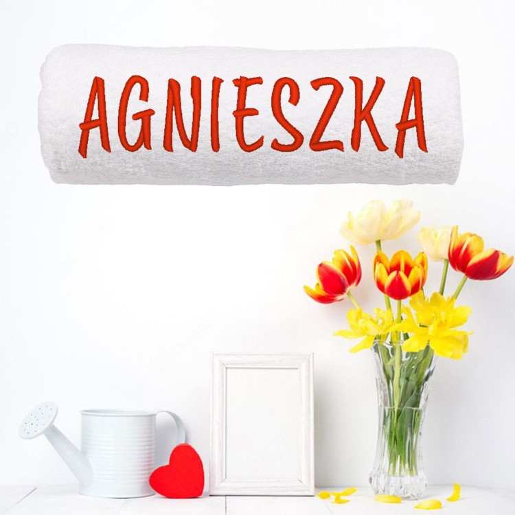 Zbliżenie na haft komputerowy z imieniem na ręczniku frotte – widoczna wysoka jakość nici i gęsty splot bawełny.
