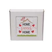 Biały ręcznik z haftem Home Sweet Home z motywem domu i serduszek zapakowany w ozdobne białe pudełko z okienkiem prezentowym.