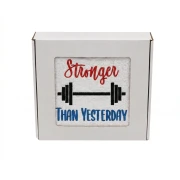 Biały personalizowany ręcznik bawełniany 500g z białym haftem przedstawiającym sztangę oraz napis „Stronger than Yesterday”, zapakowany w eleganckie pudełko z okienkiem.