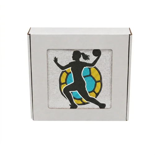 Biały personalizowany ręcznik 500g z haftem sylwetki kobiety grającej w piłkę ręczną, wykonany ze 100% bawełny, umieszczony w estetycznym opakowaniu.