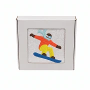 Biały personalizowany ręcznik bawełniany 500g z haftem przedstawiającym snowboardzistę wykonującego ewolucję na desce, zapakowany w eleganckie pudełko z okienkiem.