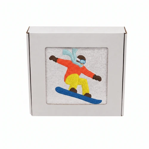 Biały personalizowany ręcznik bawełniany 500g z haftem przedstawiającym snowboardzistę wykonującego ewolucję na desce, zapakowany w eleganckie pudełko z okienkiem.
