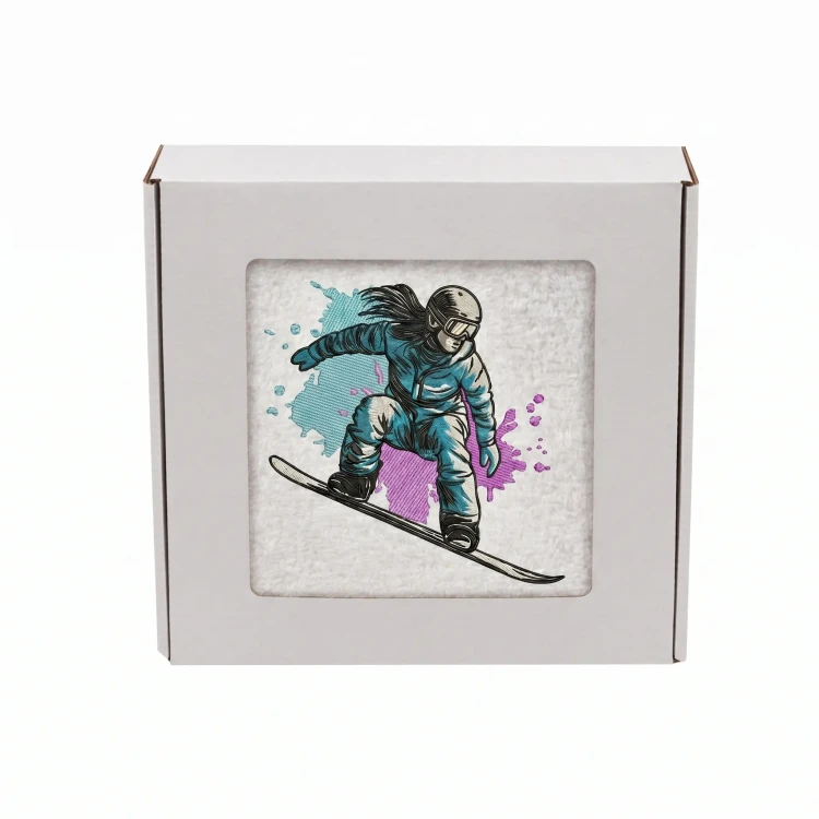 Biały personalizowany ręcznik 500g z haftem sylwetki kobiety zjeżdżającej na snowboardzie, wykonany ze 100% bawełny, umieszczony w estetycznym pudełku z okienkiem.