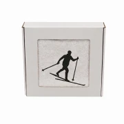 Biały personalizowany ręcznik bawełniany 500g z haftem przedstawiającym narciarza biegowego na trasie, elegancko zapakowany w pudełko z okienkiem.