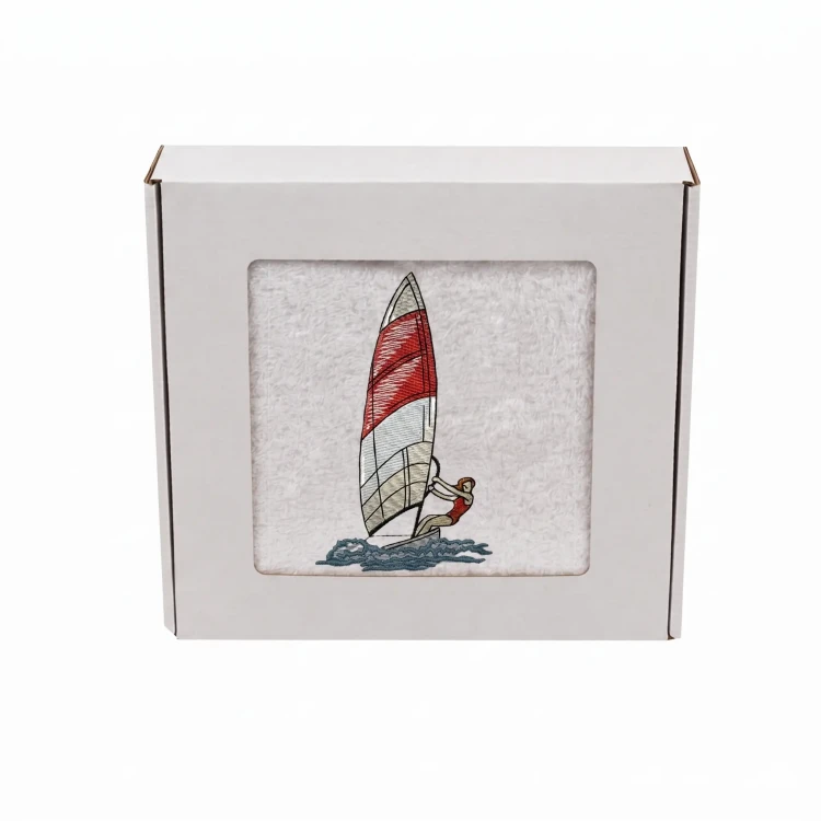 Biały personalizowany ręcznik bawełniany 500g z haftem przedstawiającym windsurfera płynącego na desce z żaglem, zapakowany w eleganckie pudełko z okienkiem.