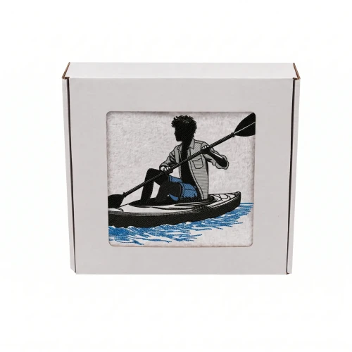 Biały personalizowany ręcznik bawełniany 500g z haftem przedstawiającym kajakarza z wiosłem na wodzie, elegancko zapakowany w pudełko z okienkiem.