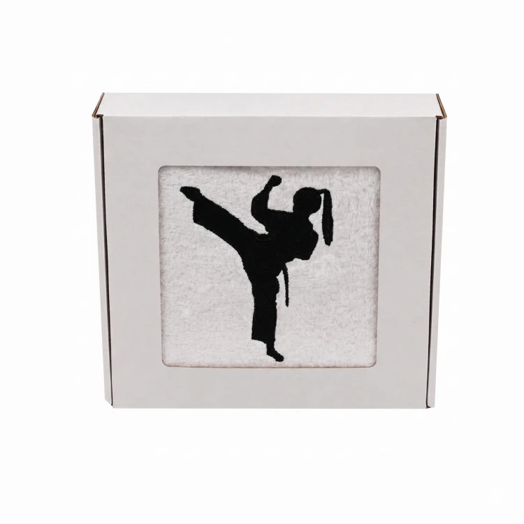 Biały personalizowany ręcznik 500g z haftem sylwetki kobiety w kimonie podczas treningu karate, wykonany ze 100% bawełny, umieszczony w estetycznym pudełku z okienkiem.