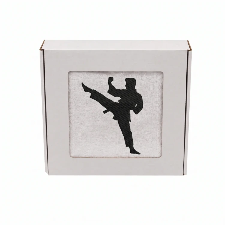 Biały personalizowany ręcznik bawełniany 500g z haftem przedstawiającym mężczyznę w kimonie wykonującego cios karate, zapakowany w eleganckie pudełko z okienkiem.
