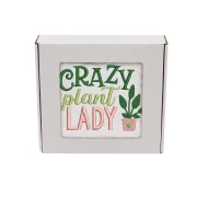 Biały bawełniany ręcznik frotte zapakowany w białe pudełko prezentowe z okienkiem. Przez okienko widoczny kolorowy haft: "CRAZY plant LADY" w kolorach zielonym, seledynowym i różowym oraz mała doniczka z sercem.