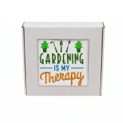 Biały ręcznik z kolorowym haftem Gardening is My Therapy i motywem narzędzi ogrodniczych, zapakowany w prezentowe pudełko z okienkiem.