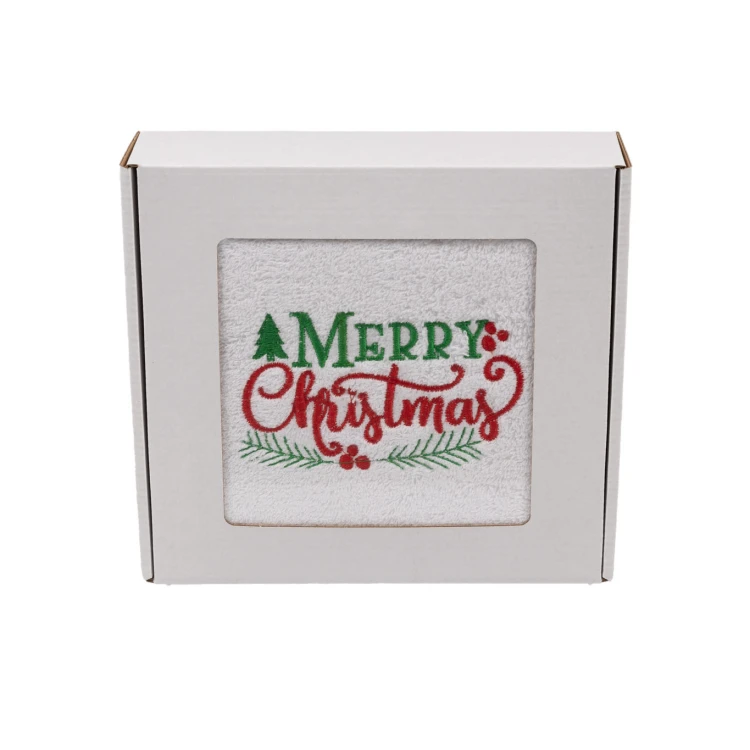 Elegancki świąteczny ręcznik frotte 500g z klasycznym haftem Merry Christmas i gałązkami ostrokrzewu, zapakowany w białe kartonowe pudełko z okienkiem, gotowy na prezent.