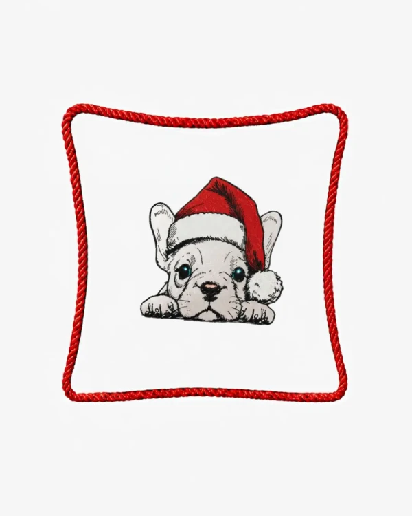 Śmietankowa poszewka welurowa 45x45 cm z haftem przedstawiającym szczeniaka rasy buldog francuski w świątecznej czapce Mikołaja, ozdobiona czerwonym sznurem wokół krawędzi.