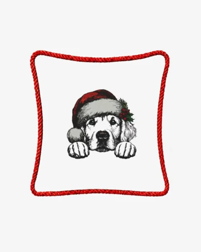 Śmietankowa poszewka welurowa 45x45 cm z haftem przedstawiającym szczeniaka rasy golden retriever w świątecznej czapce Mikołaja z gałązką ostrokrzewu, ozdobiona czerwonym sznurem wokół krawędzi.