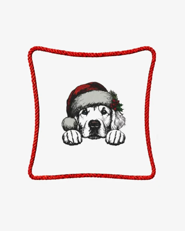 Śmietankowa poszewka welurowa 45x45 cm z haftem przedstawiającym szczeniaka rasy golden retriever w świątecznej czapce Mikołaja z gałązką ostrokrzewu, ozdobiona czerwonym sznurem wokół krawędzi.