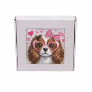 Personalizowany ręcznik frotte z precyzyjnym haftem przedstawiającym psa rasy Cavalier King Charles Spaniel w różowych okularach w kształcie serc i z kokardą, zapakowany w eleganckie białe pudełko z okienkiem.