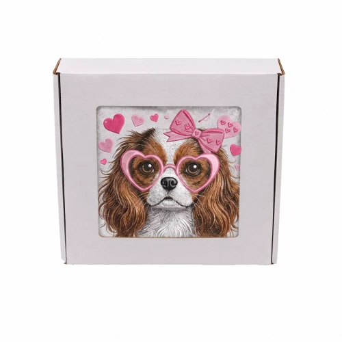 Personalizowany ręcznik frotte z precyzyjnym haftem przedstawiającym psa rasy Cavalier King Charles Spaniel w różowych okularach w kształcie serc i z kokardą, zapakowany w eleganckie białe pudełko z okienkiem.