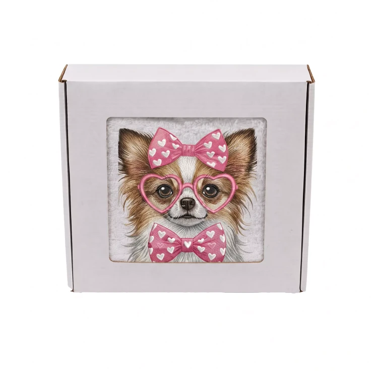 Personalizowany ręcznik frotte z precyzyjnym haftem przedstawiającym długowłosą chihuahua w różowych okularach w kształcie serc, z kokardą na głowie i pasującą muszką, zapakowany w białe pudełko prezentowe z okienkiem.