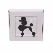 Personalizowany ręcznik frotte z precyzyjnym haftem przedstawiającym elegancką sylwetkę psa rasy pudel w klasycznej fryzurze, zapakowany w białe pudełko z okienkiem.