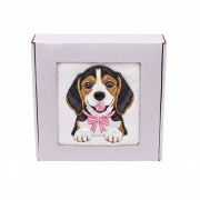 Personalizowany ręcznik frotte z precyzyjnym haftem przedstawiającym uroczego psa rasy beagle z różową muszką, zapakowany w białe pudełko z okienkiem.