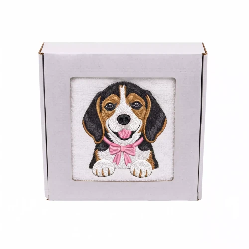 Personalizowany ręcznik frotte z precyzyjnym haftem przedstawiającym uroczego psa rasy beagle z różową muszką, zapakowany w białe pudełko z okienkiem.