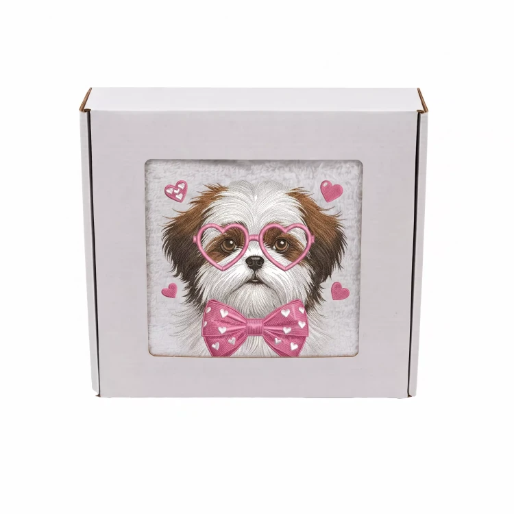 Personalizowany ręcznik frotte z precyzyjnym haftem przedstawiającym psa rasy shih tzu w różowych okularach w kształcie serc i z muszką w serduszka, zapakowany w białe pudełko z okienkiem.