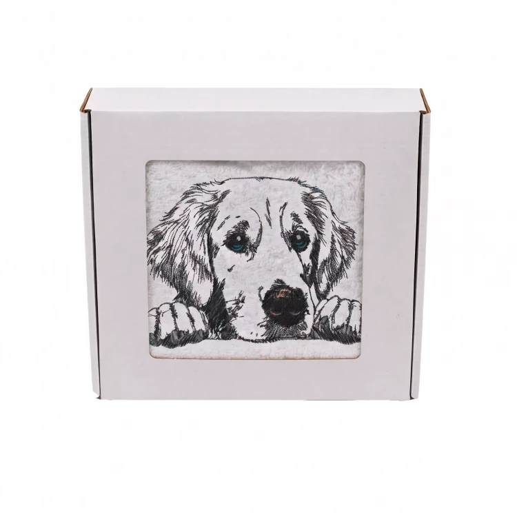 Personalizowany ręcznik frotte z precyzyjnym haftem przedstawiającym przyjaznego psa rasy golden retriever z łapkami opartymi na krawędzi, zapakowany w białe pudełko z okienkiem.